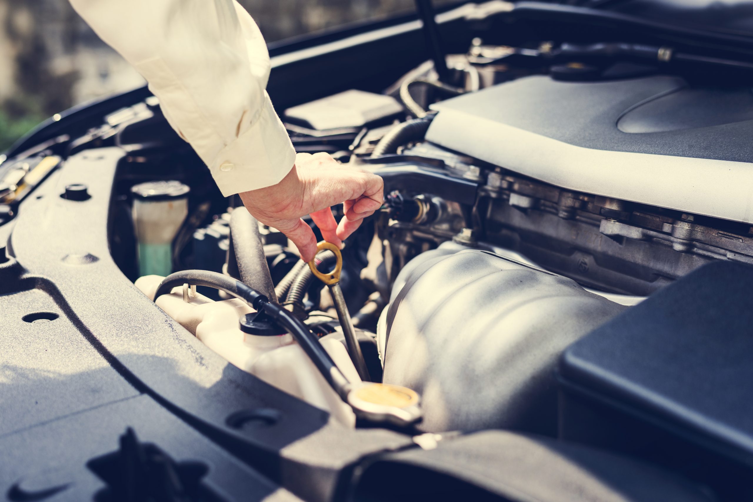 Why You Need an Oil Catch Can with Your EGR System - person checking oil in car