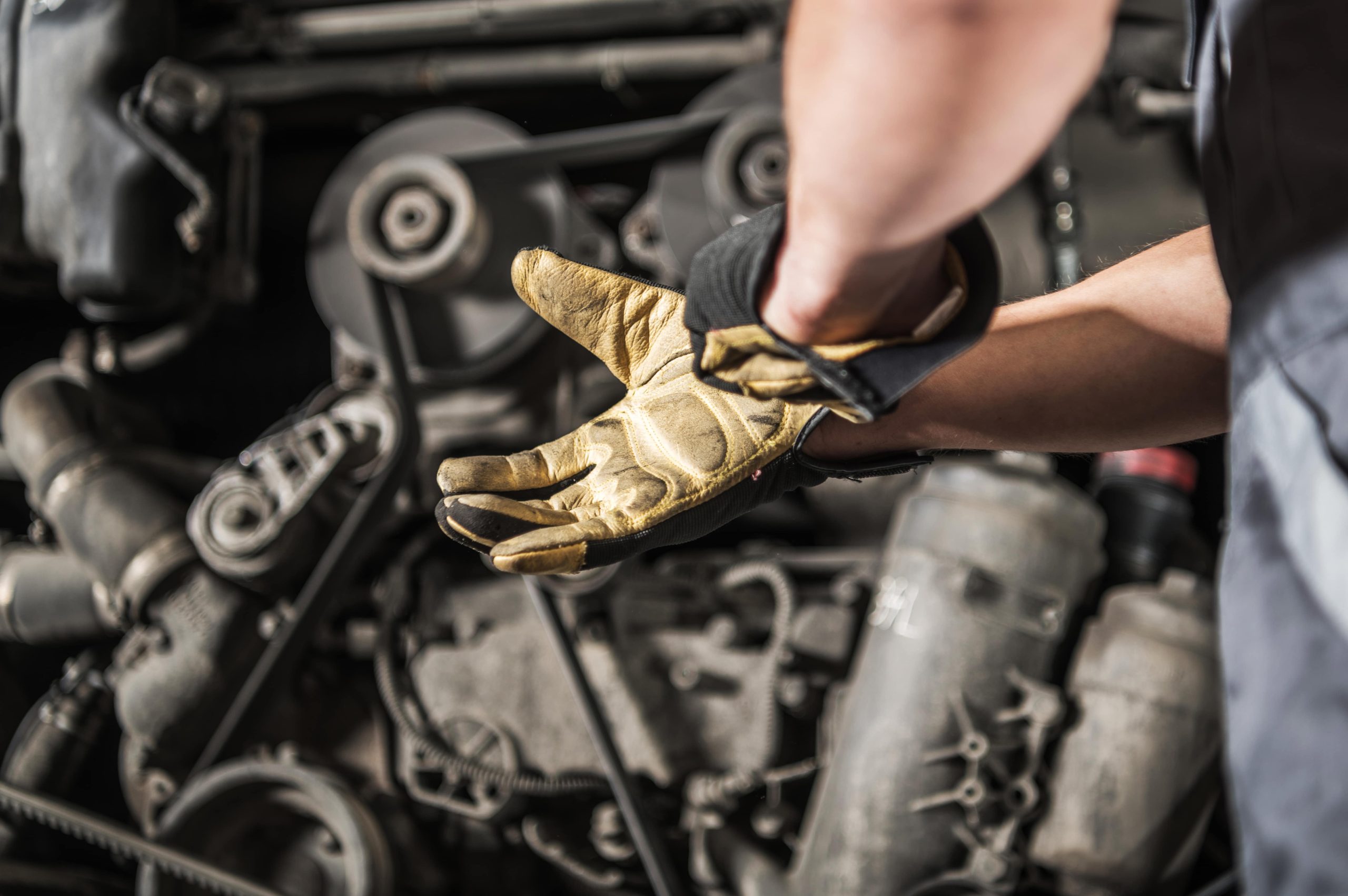 How to Tell if Your Diesel Fuel Injectors Need Replacing - mechanic in front of car with gloves on