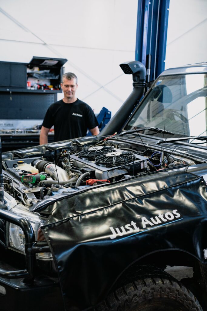 Diesel performance technician at Just Autos working on a diesel engine with a common rail injection system