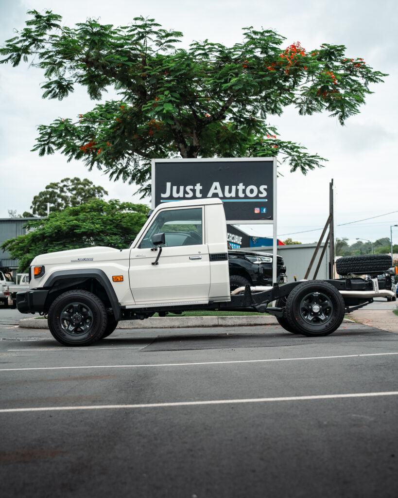 The side of Toyota's 2024 70 series in white, sitting outside Just Autos performance specialists in Nambour